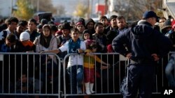 Migrants wait to register with police at a refugee center in the southern Serbian town of Presevo, Nov. 16, 2015.