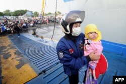 Para pemudik antre memasuki feri di pelabuhan Gilimanuk di Jembrana, Bali, untuk mudik ke kampung halaman di Jawa menjelang Hari Raya Idul Fitri, Senin, 1 Juni 2019. (Foto: AFP)