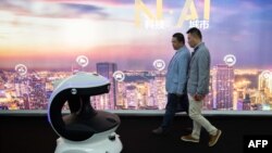 北京中國國際展覽中心: 第十四屆中國國際公共安全與保安展覽會上，參觀者走過一個裝配面部識別系統的保安機器人