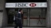 FILE - A man walks past a HSBC branch in Mexico City.