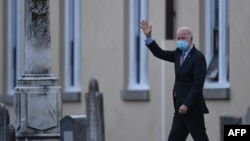 (FILES) In this file photo US President-elect Joe Biden waves as he leaves St. Joseph on the Brandywine Roman Catholic Church on January 16, 2021 in Wilmington, Delaware.