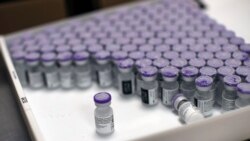 FILE - Frozen vials of the Pfizer-BioNTech COVID-19 vaccine are taken out to thaw, at the MontLegia CHC hospital in Liege, Belgium, Jan. 4, 2021. U.S. President Joe Biden is calling for a summit to address shortages in global vaccine supplies.