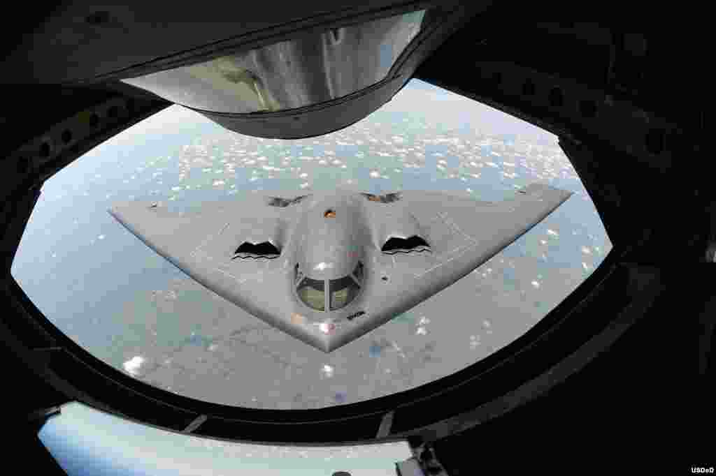 A U.S. Air Force B-2 Spirit bomber aircraft approaches the rear of a KC-135 Stratotanker aircraft before refueling during a training mission over the Midwest. The B-2&#39;s unique design enables it to travel into enemy territory to deploy ordnance without being detected by radar. (DoD photo by Airman 1st Class John Linzmeier, U.S. Air Force/Released on Aug.7, 2013)