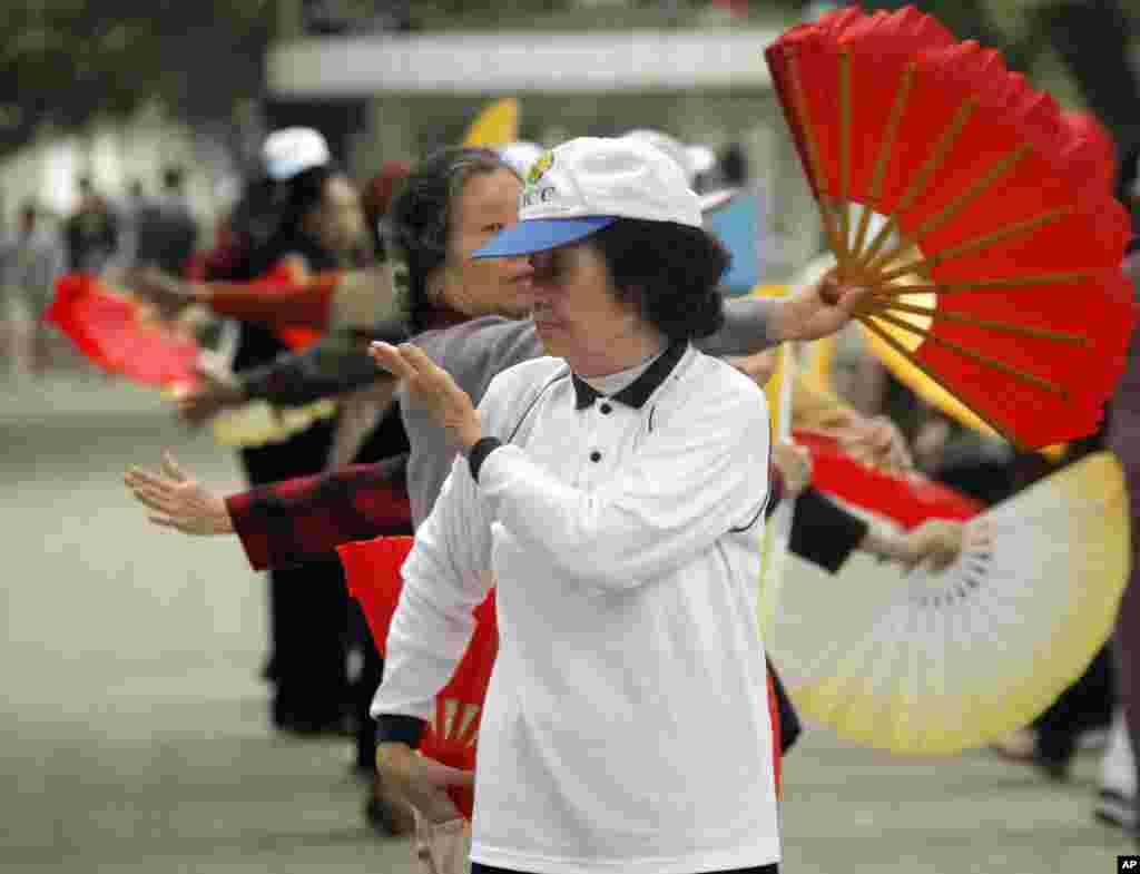 Nguyen Ngoc Ho, 76, performs fan dancing with others along the shores of Hoan Kiem Lake in Hanoi, Vietnam. Fan dancing is a popular hobby among Vietnamese women. 