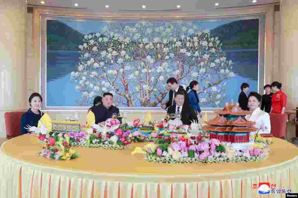 Pemimpin Korea Utara Kim Jong Un dan istrinya Ri Sol Ju menghadiri jamuan makan malam bersama tuan rumah, Presiden Cina Xi Jinping dan istrinya Peng Liyuan di Beijing, China, dalam sebuah foto yang dirilis oleh Kantor Berita Korea Korea Utara (KCNA).