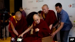 流亡西藏精神領袖達賴喇嘛在助手攙扶下抵達新德里的一次活動現場。 （2019年4月4日）