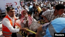 An injured man from Syrian town of Kobani is carried to a hospital at the Turkish-Syrian border town of Suruc, in Sanliurfa province, Turkey, June 25, 2015.