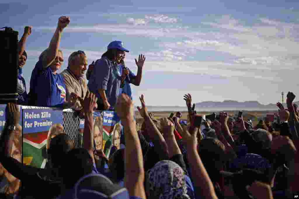 South African opposition leader Helen Zille, second from left, from the Democratic Alliance, raises her hand during a rally in Rocklands, on the outskirts of Cape Town, South Africa, May 6, 2014.