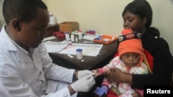 FILE - Seorang dokter memeriksa seorang anak untuk malaria di sebuah rumah sakit di Arusha, Tanzania, 11 Mei 2016. 