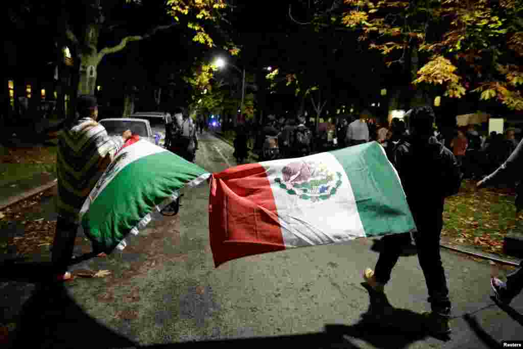 Marchers are pictured with Mexican flags as they protest the election of Republican Donald Trump as President of the United States in Seattle, Washington, U.S., Nov. 9, 2016.
