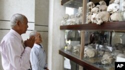 Survivors of the Khmer Rouge regime, Chum Mey (L) and Bou Meng (C) pray at Choeung Ek "Killing Fields" site located on the outskirts of Phnom Penh, June 25, 2011.