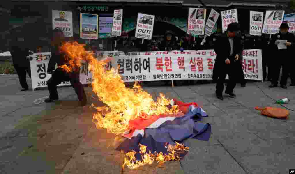 South Korean protesters burn a North Korean flag following a report of the nuclear test conducted by North Korea, in Seoul, South Korea, February 12, 2013. 