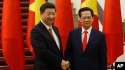 FILE - Chinese President Xi Jinping, left, poses for a photo with Vietnam's Prime Minister Nguyen Tan Dung before their meeting in Hanoi, Nov. 5, 2015. 