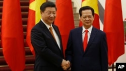 Chinese President Xi Jinping, left, poses for a photo with Vietnam's Prime Minister Nguyen Tan Dung before their meeting at the Government Office, Hanoi, Nov. 5, 2015. 
