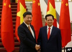 FILE - Chinese President Xi Jinping, left, poses for a photo with Vietnam's Prime Minister Nguyen Tan Dung before their meeting at the Government Office in Hanoi, Nov. 5, 2015.