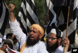 FILE - Supporters of Jamiat-e-Ulema Islam, a Pakistani religious group, chant slogans during a demonstration to condemn a suicide bombing, in Lahore, Pakistan, May 14, 2017. The Islamic State group said it orchestrated a suicide attack on Abdul Ghafoor Haideri, a Pakistani lawmaker, in the country's southwest, which killed 25 people.