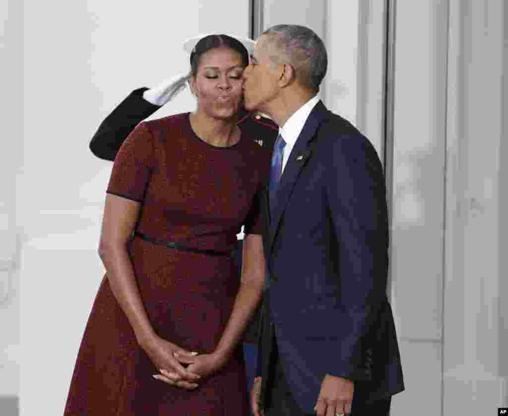 Tổng Thống Barack Obama hôn vợ, Đệ Nhất Phu Nhân, Michelle Obama, khi hai người đứng đợi sự xuất hiện của hai vợ chồng tổng thống tân cử, Donald Trump và Melania, sáng 20 tháng Giêng, Tòa Bạch Ốc, Washington. (AP Photo/Evan Vucci)