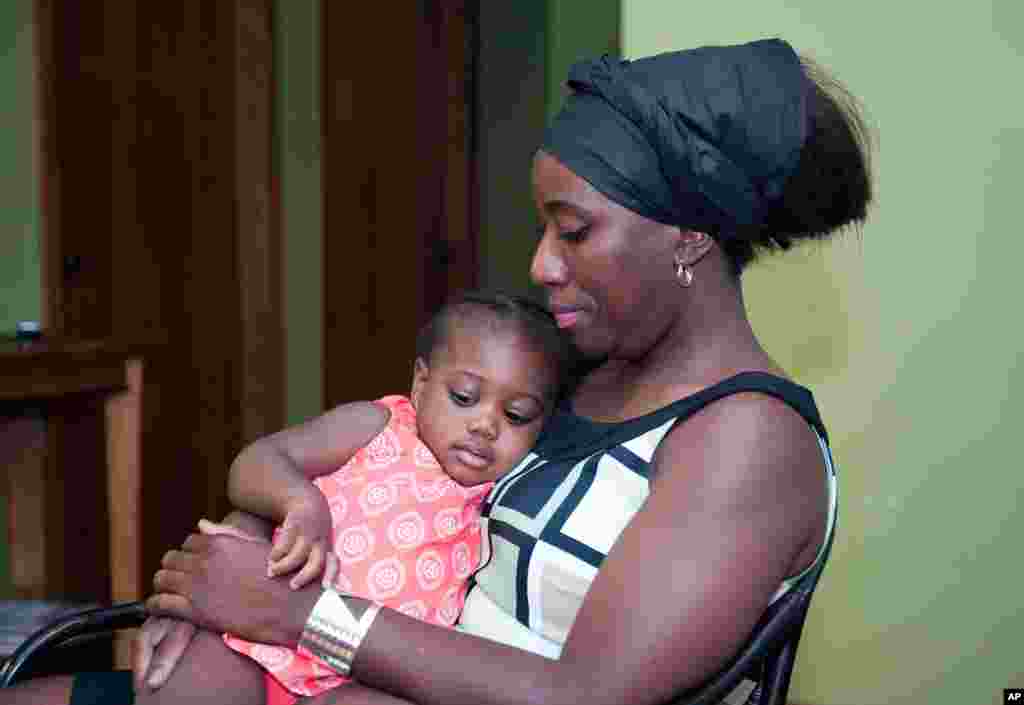 Decontee Sawyer, wife of Liberian government official Patrick Sawyer, a U.S. citizen who died from Ebola after traveling from Liberia to Nigeria, cradles her 1-year-old daughter, Bella, at her home in Coon Rapids, Minnesota, July 29, 2014.&nbsp;