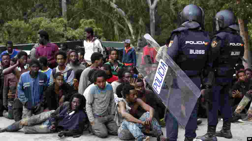 Des migrants sont assis sur un &nbsp;terrain, Ceuta, le 17 février 2017.