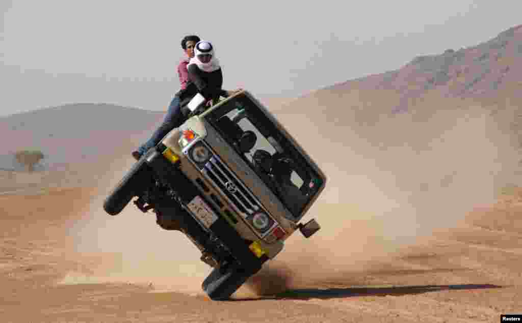 Saudi youths demonstrate a stunt known as &quot;sidewall skiing&quot; (driving on two wheels) in the northern city of Hail, in Saudi Arabia. Performing stunts such as sidewall skiing and drifts is a popular hobby amongst Saudi youths. 