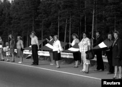 Orang-orang bergandengan tangan dalam rantai manusia pada aksi "Jalan Baltik" dekat Riga, Latvia, 23 Agustus 1989.