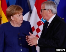 German Chancellor Angela Merkel is welcomed by EU President Jean-Claude Juncker at the start of an emergency European Union leaders summit on immigration at the EU Commission headquarters in Brussels, Belgium, June 24, 2018.