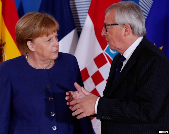 German Chancellor Angela Merkel is welcomed by EU President Jean-Claude Juncker at the start of an emergency European Union leaders summit on immigration at the EU Commission headquarters in Brussels, Belgium, June 24, 2018.