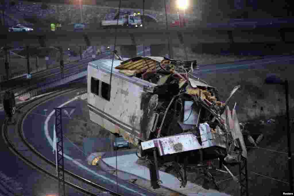 Cần cẩu kéo một toa xe lửa vỡ nát ra khỏi hiện trường tai nạn gần Santiago de Compostela, miền bắc Tây Ban Nha, 25 tháng 7 năm 2013. 
