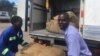 Felix Tarutsvira, right, works with another Zimbabwe farmer to take their tobacco to an auction floor in Harare. They say they prefer the "golden leaf," as it offers them better returns than maize, the country’s staple crop, March 2017. (S. Mhofu/VOA)