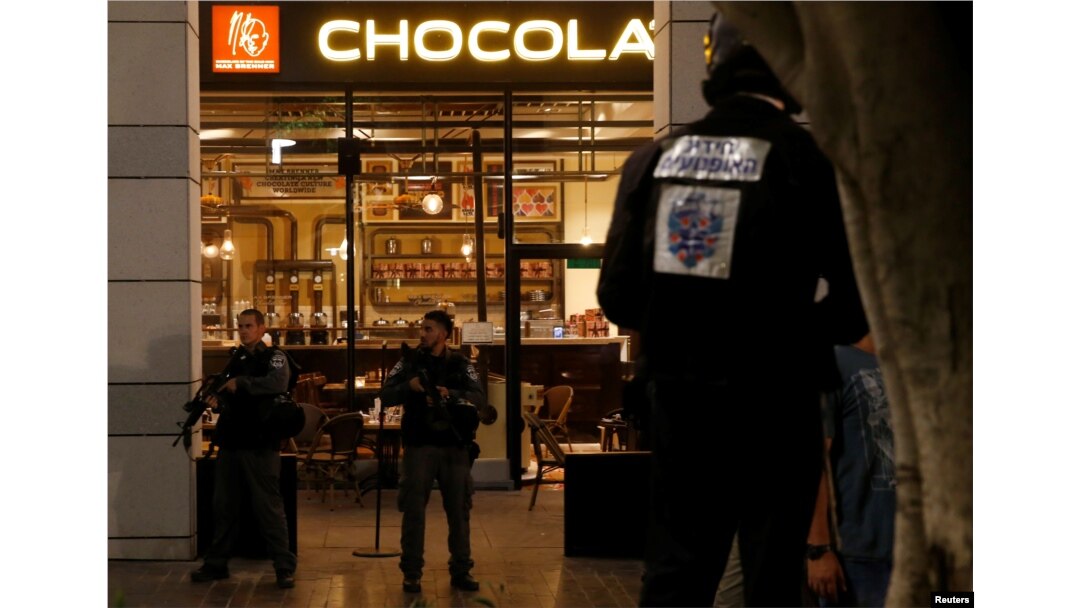 Israeli policemen secure the entrance to a restaurant following a shooting attack in the center of Tel Aviv, June 8, 2016.