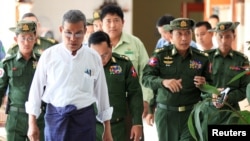 FILE - Rakhine Chief Minister Nyi Pu, left, and Myanmar's high ranking military officers walk after a daytrip with a diplomatic mission and United Nations officials to the Maungdaw area in northern Rakhine State in Myanmar, Nov. 3, 2016.
