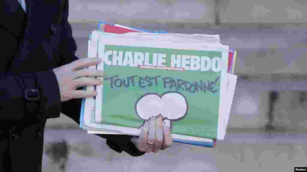 Le Premier ministre français Manuel Valls, avec un exemplaire de Charlie Hebdo en mian, quitte la réunion hebdomadaire du cabinet à l&#39;Elysée à Paris, France, le 14 janvier 2015.