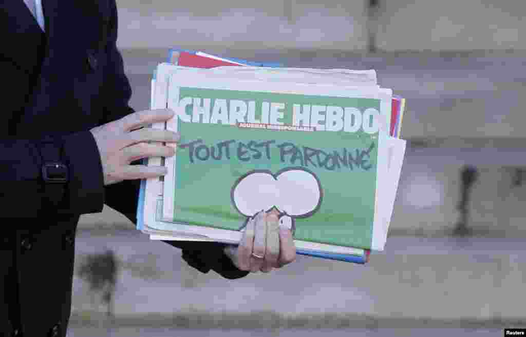 French Prime Minister Manuel Valls holds a copy of Charlie Hebdo as he leaves the weekly cabinet meeting at the Elysee Palace in Paris, France, Jan. 14, 2015.