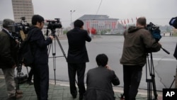 ညီလာခံကျင်းပရာ အဆောက်အဦး အဝေးကနေ သတင်းဓာတ်ပုံ ရိုက်ယူနေရတဲ့ နိုင်ငံတကာ သတင်းထောက်များ။ 