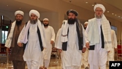 FILE - Members of the Taliban delegation walks down a hotel lobby during talks in Qatar's capital Doha, Aug.12, 2021.