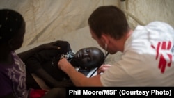 A Médecins Sans Frontières (MSF) doctor treats a girl who suffered an electric shock, at the MSF clinic set up at the camp for displaced people in the grounds of the United Nations Mission to South Sudan (UNMISS) base in Juba, South Sudan, on January 12,