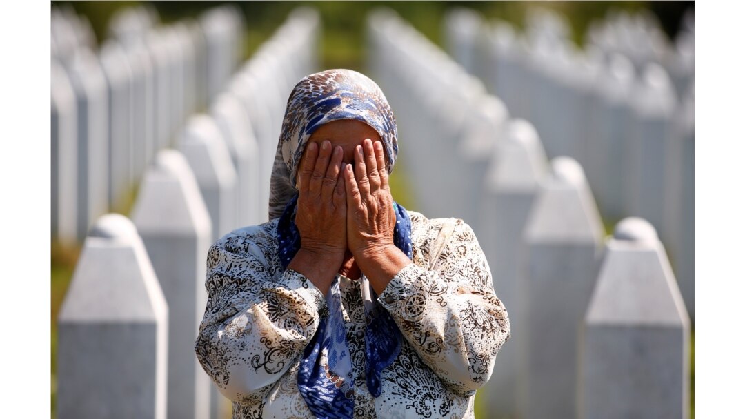 A woman prays at a graveyard, ahead of a mass funeral in Potocari near Srebrenica, Bosnia and Herzegovina July 11, 2020. Bosnia marks the 25th anniversary of the massacre of more than 8,000 Bosnian Muslim men and boys, with many relatives unable to attend
