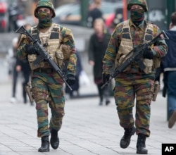 FILE - Belgian soldiers patrol outside a court building where Salah Abdeslam, the top suspect in last year's deadly Paris attacks, was expected to appear before a judge in Brussels, Belgium, March 24, 2016.