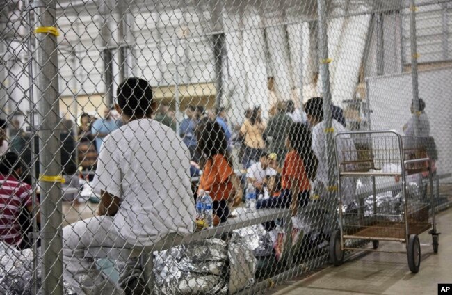 En esta foto proporcionada por la agencia de Aduanas y Protección Fronteriza de EE.UU., personas que han sido detenidas por entrada ilegal a Estados Unidos, permanecen en una de las jaulas de una instalación en McAllen, Texas, el domingo 17 de junio de 2018.