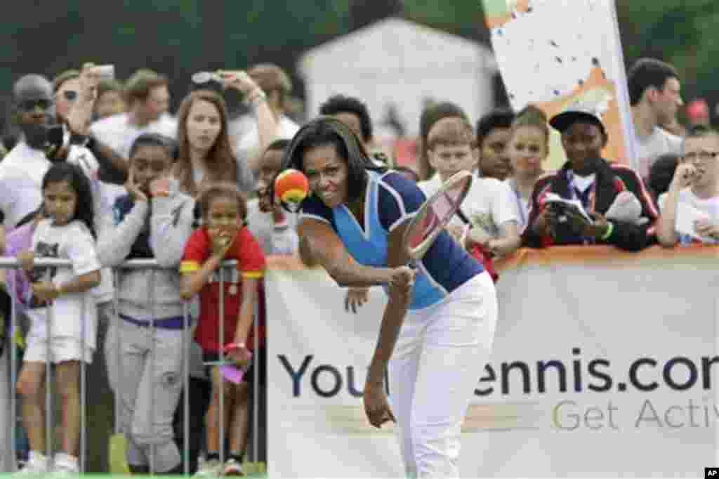 U.S. first lady Michelle Obama plays tennis with schoolchildren during a 'Let's Move!' event for about 1,000 American military children and American and British students at the U.S. ambassador's residence in London, ahead of the 2012 Summer Olympics, Frid