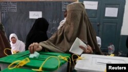 A woman casts her ballot at a polling station in Peshawar May 11, 2013.