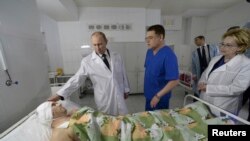 Presiden Rusia Vladimir Putin (kiri) menjenguk seorang penyintas dari salah satu insiden ledakan bom di rumah sakit lokal Volgograd (1/1).
