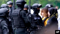 The suspects Siti Aisyah and Doan Thi Huong, second from right are escorted by police officers from Sepang court in Sepang, Malaysia on March 1, 2017.