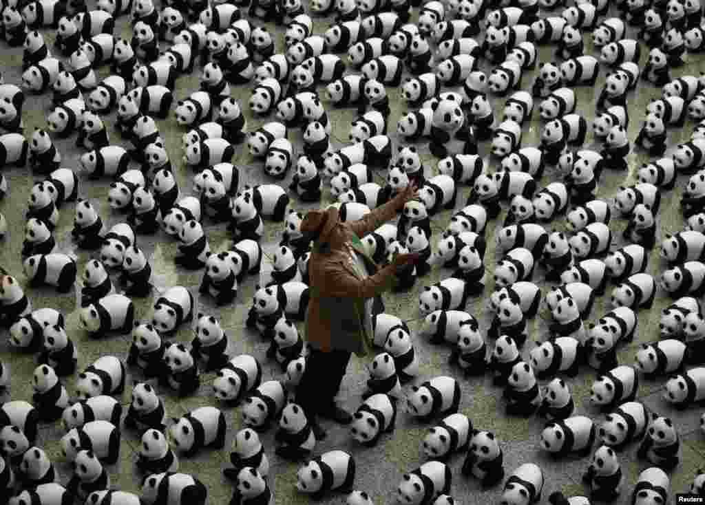 French artist Paulo Grangeon throws one of his papier-mache pandas displayed at the arrival hall of the Hong Kong airport.&nbsp; The installation is part of&nbsp; the &quot;1,600 Pandas World Tour in Hong Kong: Creativity Meets Conservation.&quot;