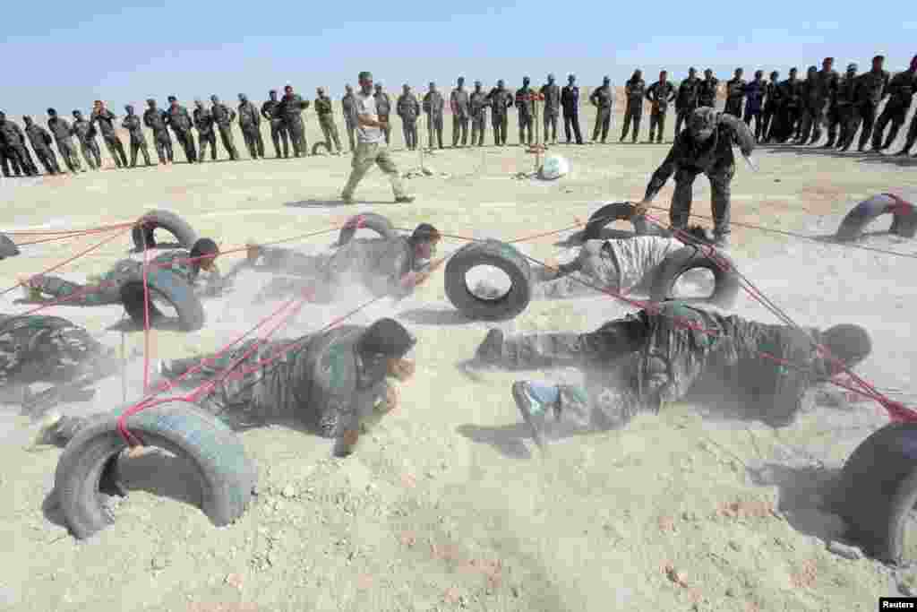 Shi'ite fighters, who have joined the Iraqi army to fight against militants of the Islamic State take part in field training in the desert in the province of Najaf, Sept. 16, 2014.