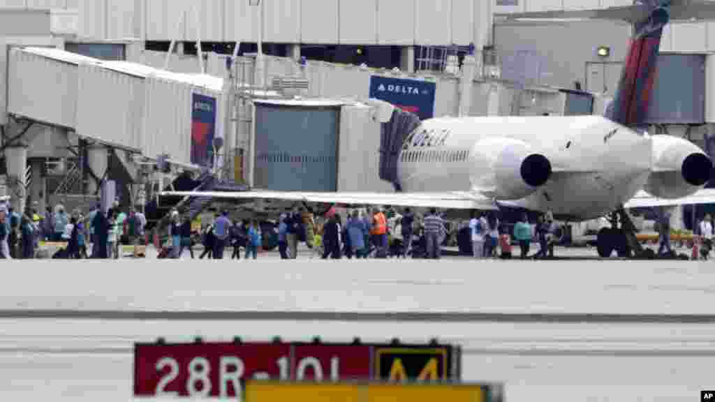 Les passagers sont évacués du terminal après des tirs à l&#39;aéroport international de Fort Lauderdale Floride, le 6 janvier 2017.