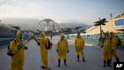 Des agents de santé se préparent pour pulvériser l'insecticide contre le moustique Aedes aegypti qui transmet le virus Zika, sous les gradins du Sambadrome de Rio de Janeiro, au Brésil, le 26 janvier 2016. (AP Photo/Leo Correa)