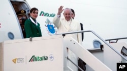 Paus Fransiskus meambaikan tangan sesaat sebelum memasuki pesawat di bandara Fiumicino, Roma menuju meksiko (12/2). 