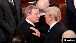FILE - U.S. President Donald Trump (R) talks with U.S. Supreme Court Chief Justice John Roberts as he departs after delivering his State of the Union address to a joint session of the U.S. Congress on Capitol Hill in Washington, U.S. January 30, 2018. (REUTERS/Jonathan Ernst)