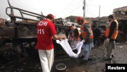 Rescue workers collect body parts after a bomb attack at Fauji Market in Peshawar, December 17, 2012.